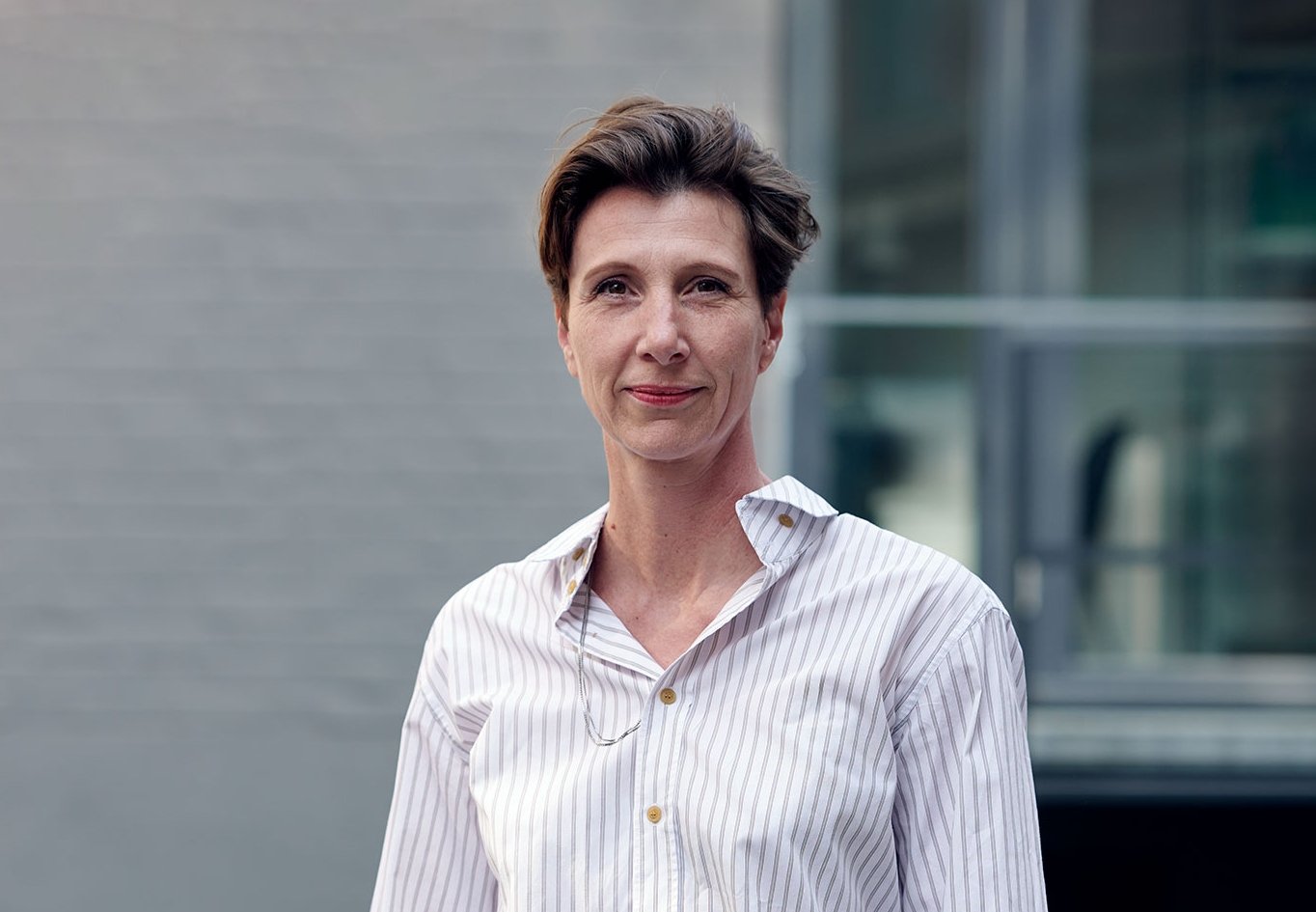 a professional photo of Nikola Dietrich, a woman with short hair and a crisp pale shirt