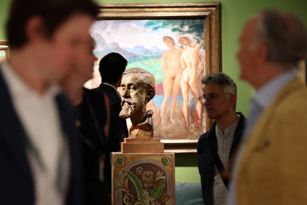 art enthusiasts looking at a sculpture of a head