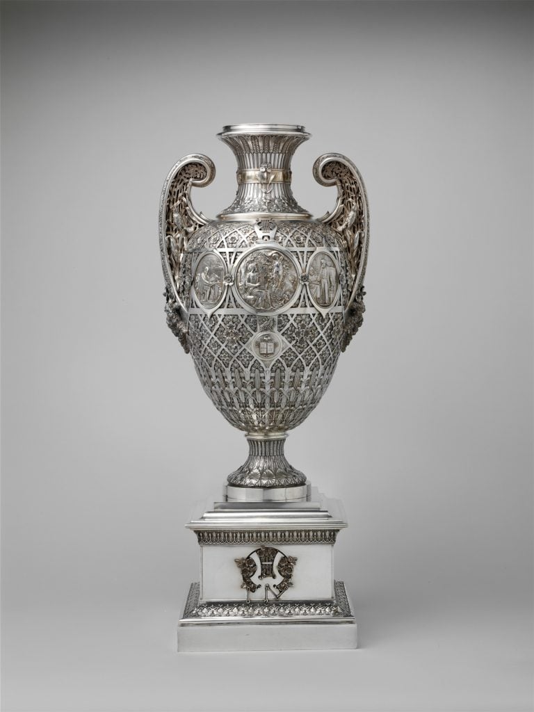 an intricately carved silver vase