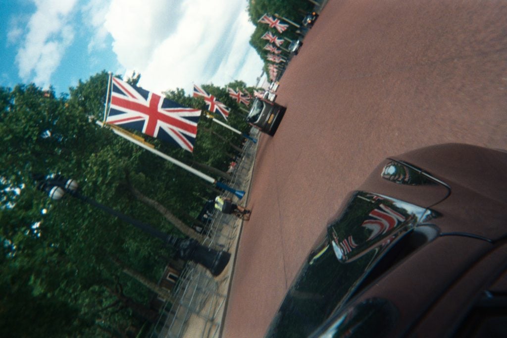 photo of lined up uk flags on a red road