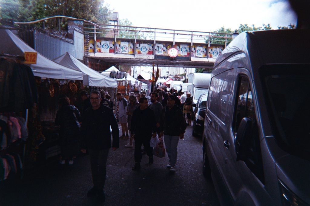 photo of outdoor market under a bridge on a cloudy day