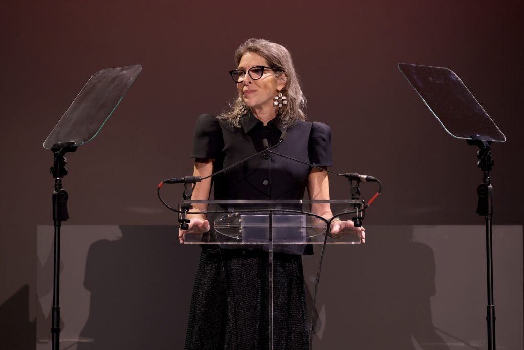 Anne Pasternak speaking at a podium onstage at the 2024 Brooklyn Artists Ball.