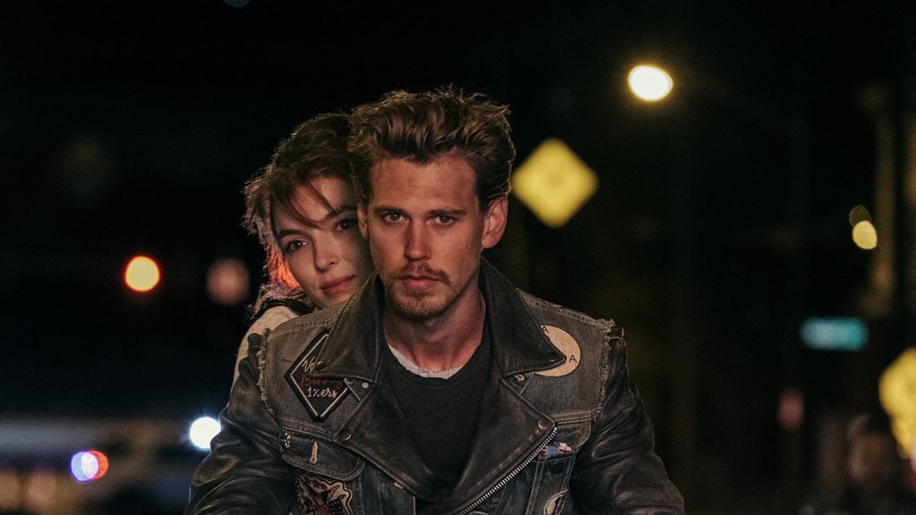 A still from the film The Bikeriders, showing a man and woman against a nocturnal city scene
