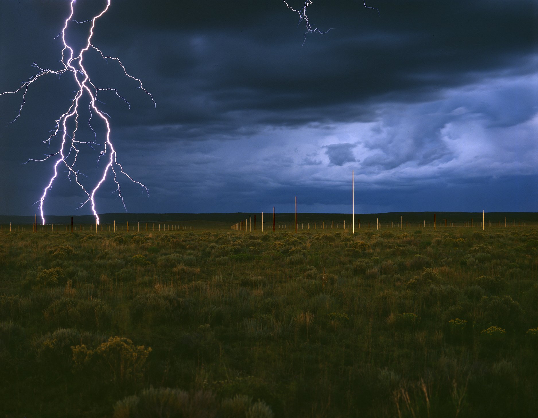 photograph of lighting in an open field striking a rod