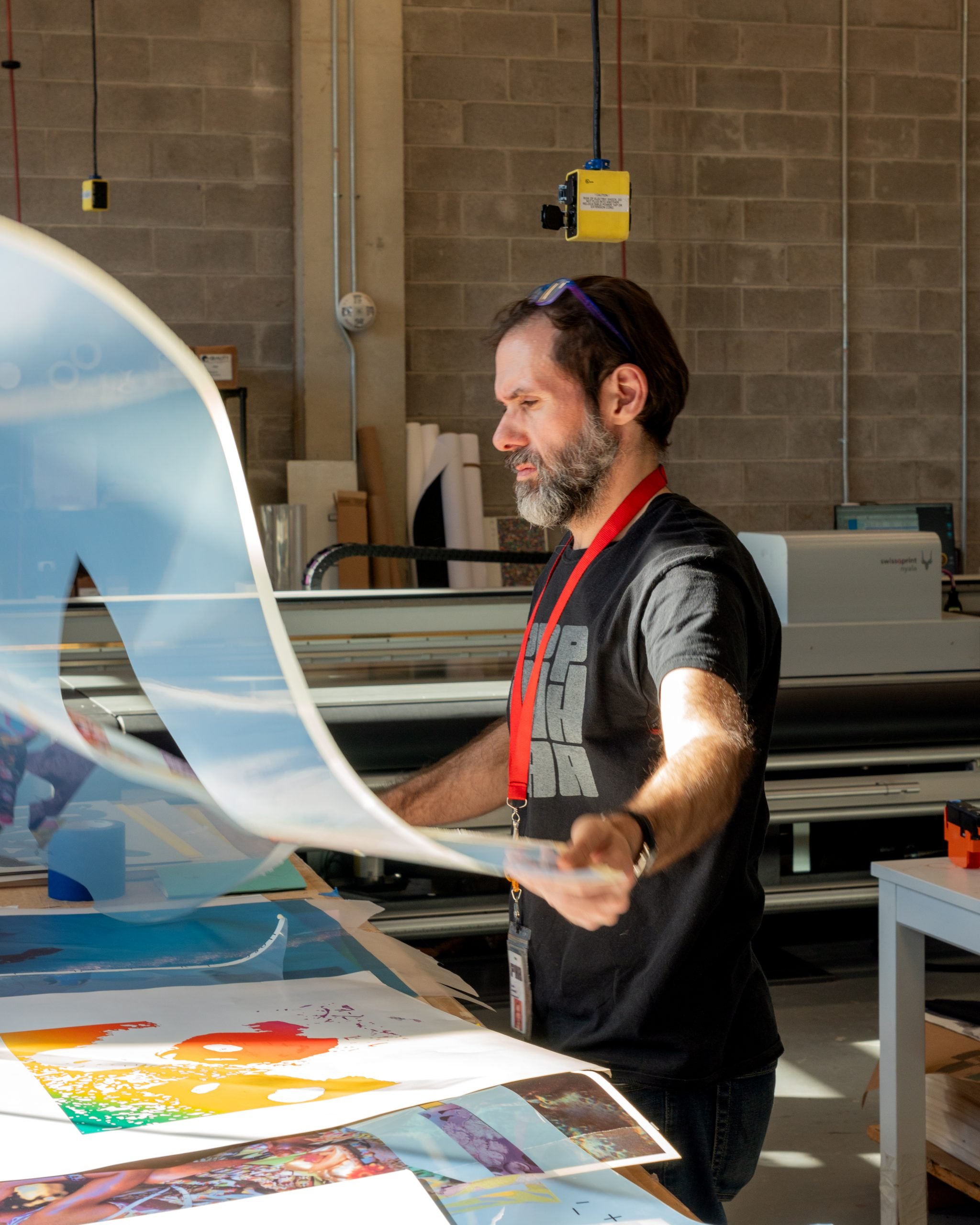 Portrait of Powerhouse Arts printmaker Dennis Hrehowik working in the new lab, pulling a new print.