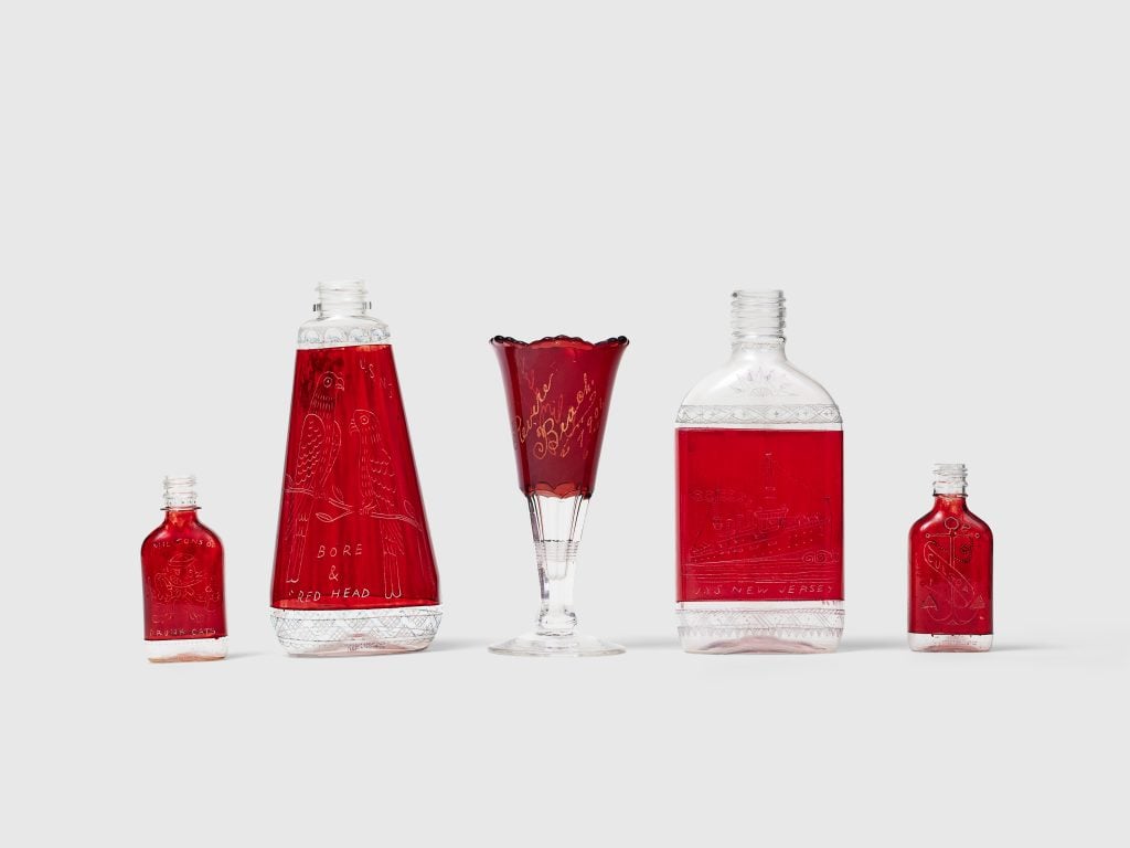 Five ruby-tinted plastic bottles of various sizes