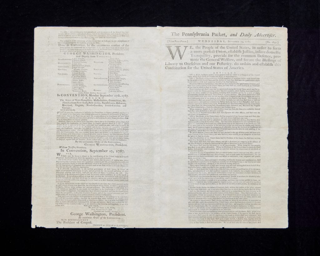 An antique copy of the U.S. Constitution in a contemporary newspaper