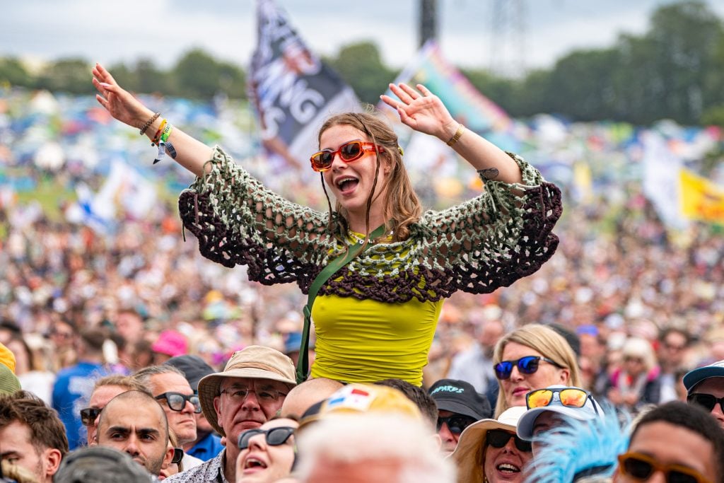A woman held aloft amid a massive crowd of people at Glastonbury Festival