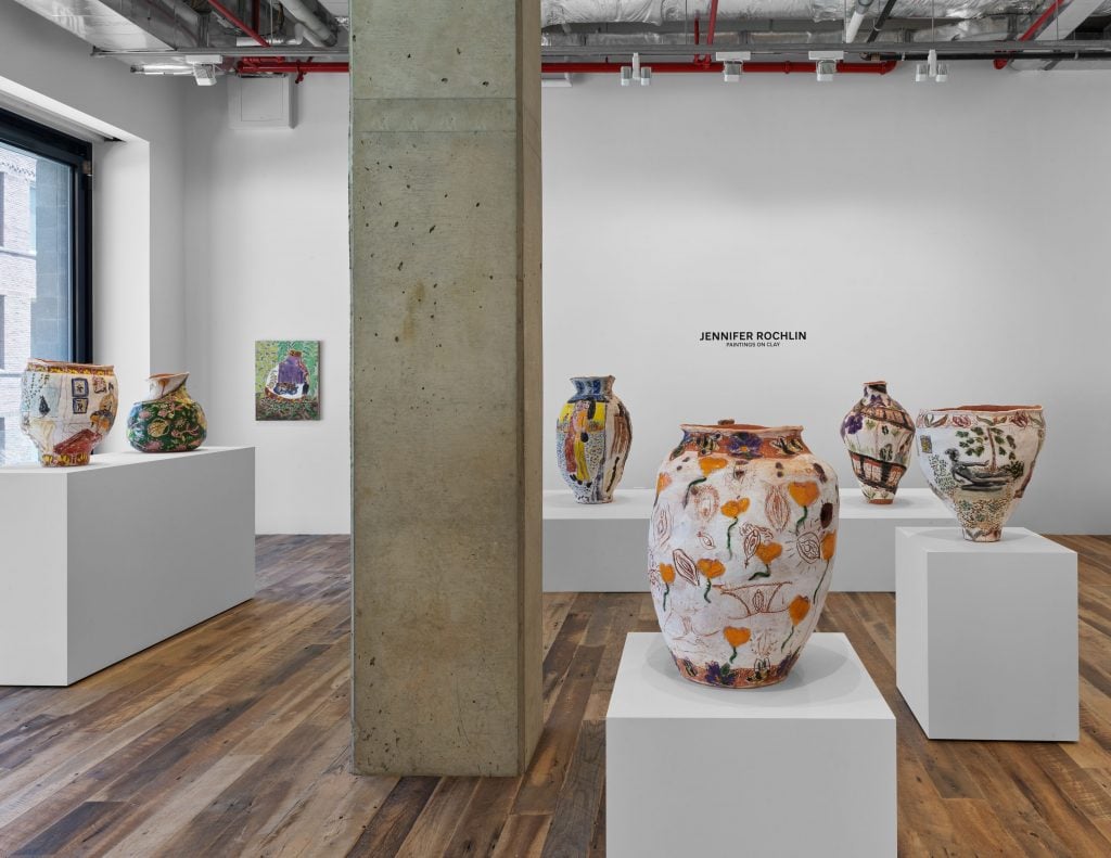 Installation view of solo exhibition of terracotta pots by artist Jennifer Rochlin; six are viewable across several plinths and pedestals, with the artist's name vinyl on the back wall.