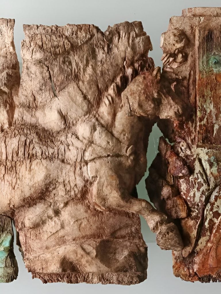 一块古老的象牙碎片，上面雕刻着一名骑着战车的男子的图像。