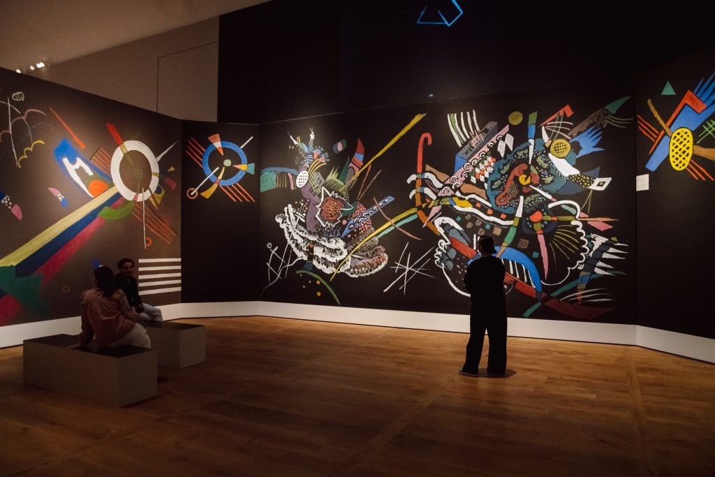A gallery surrounded by murals featuring recreation of Wassily Kandinsky's geometric forms