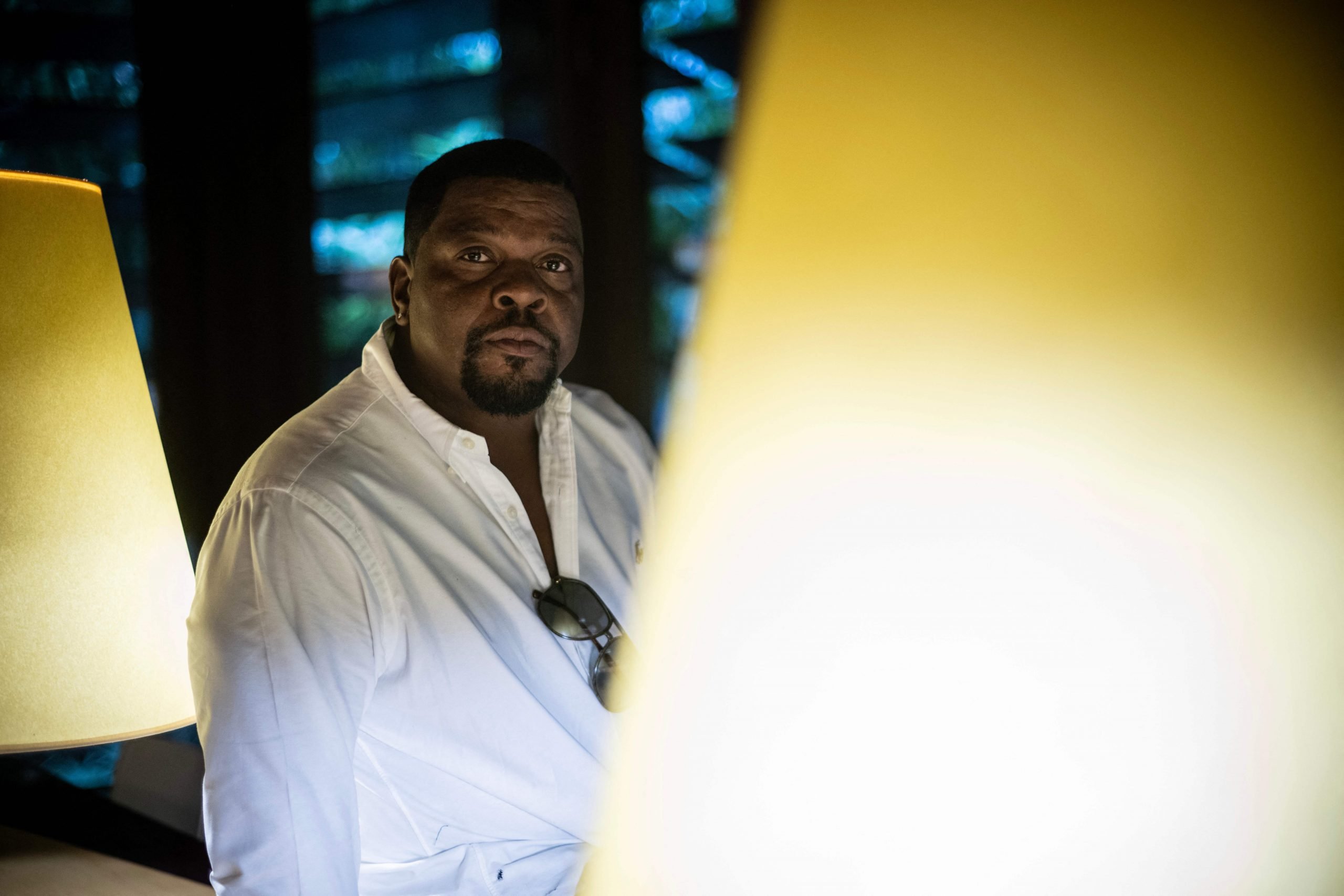 Artist Kehinde Wiley posed between two lamps