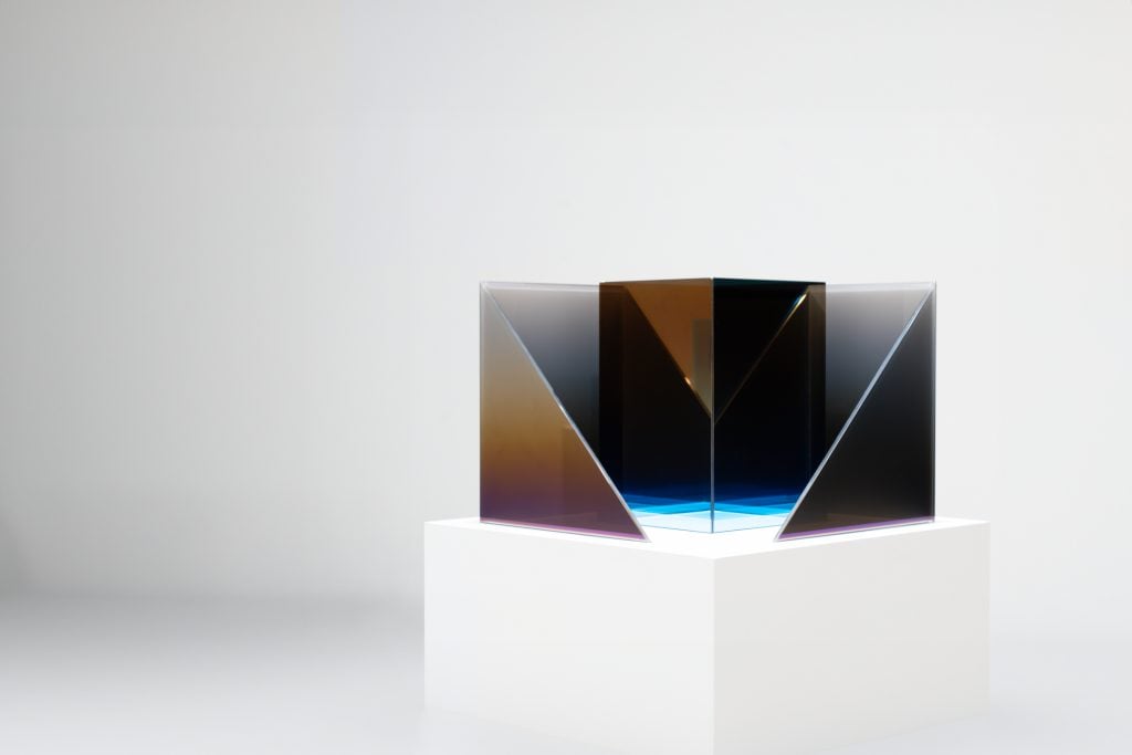 photograph of larry bell glass sculpture on a white pedestal