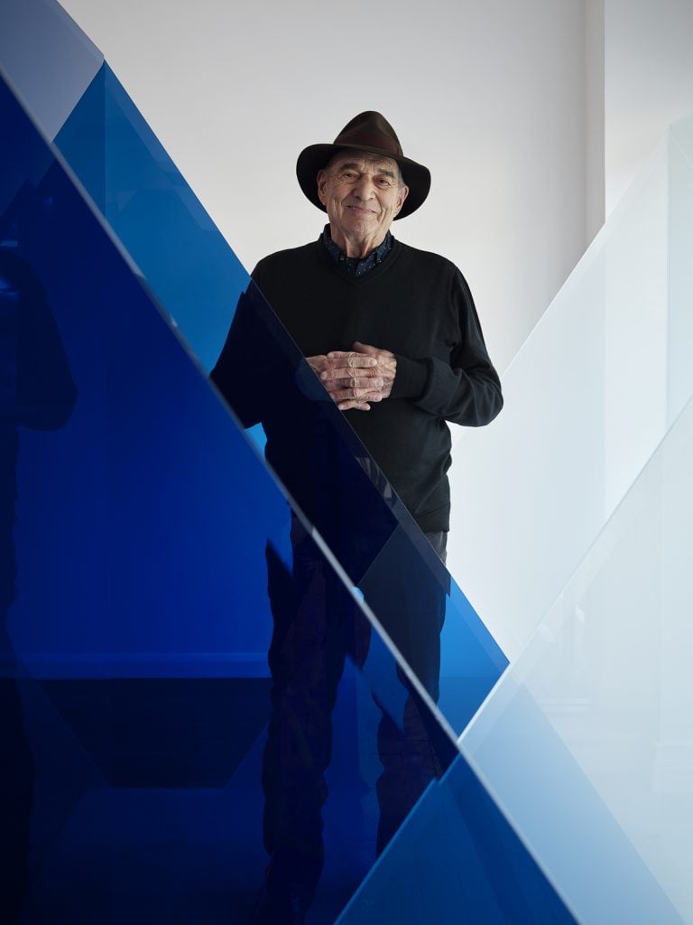 portrait of larry bell within one of his blue glass sculptures