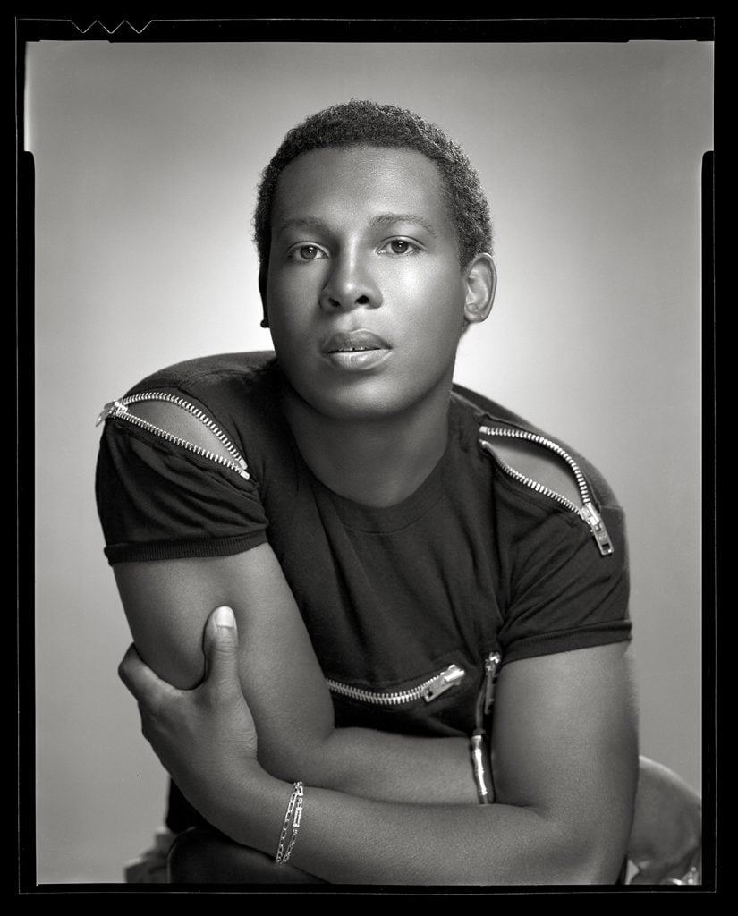 a luminous early portrait of the singer Sylvester he wears a shirt with zippered shoulders 