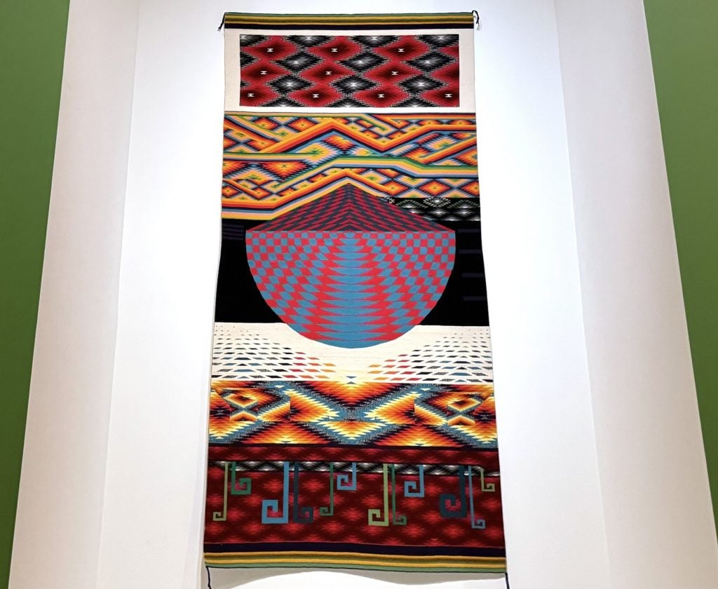 A complex wall hanging featuring multiple brightly colored patterns
