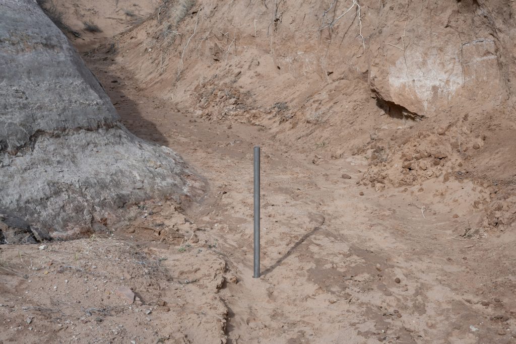 photograph of a steel pipe placed in a rocky path