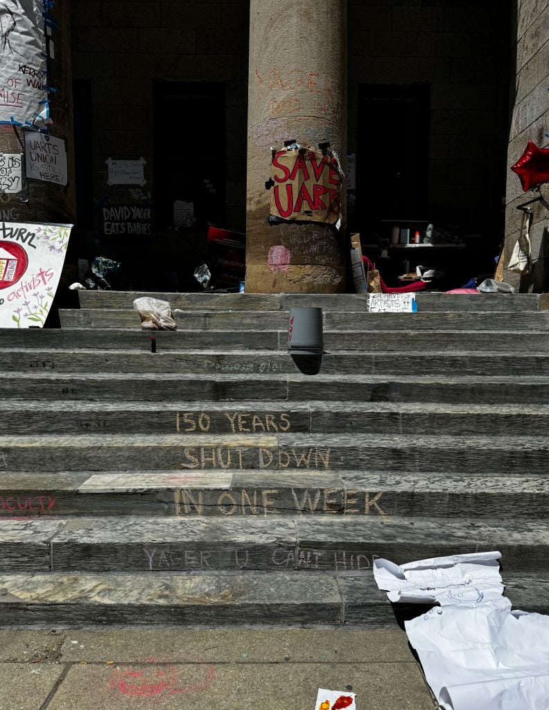 A set of steps covered in chalk graffiti, one of which reads "150 years shut down in one week."