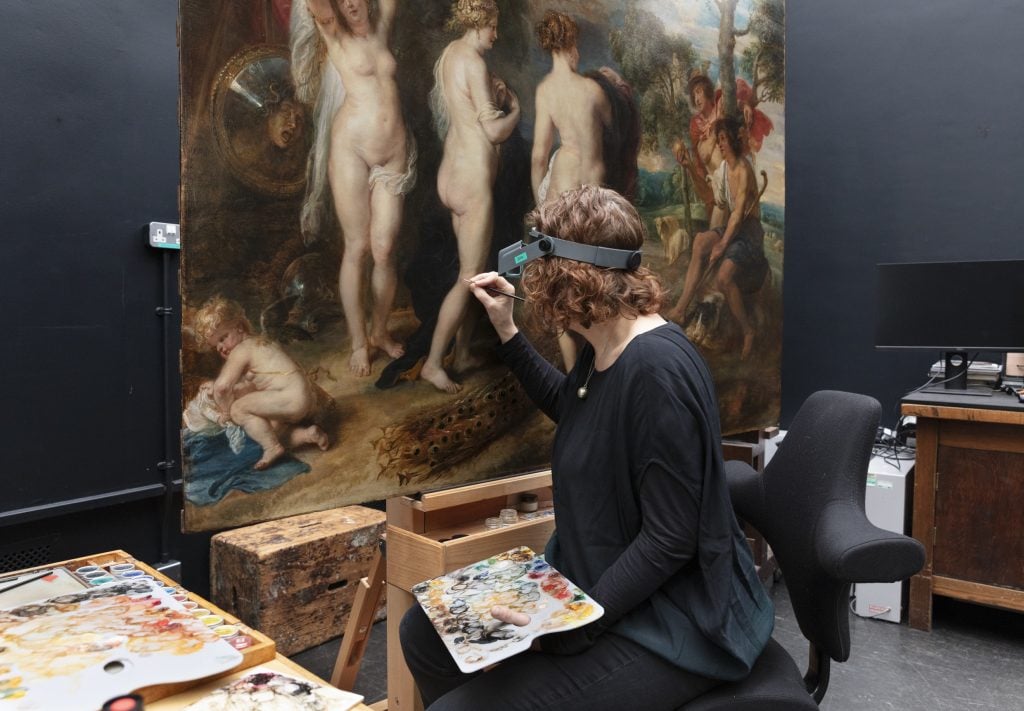 A conservator working on the Peter Paul Rubens painting, The Judgement of Paris