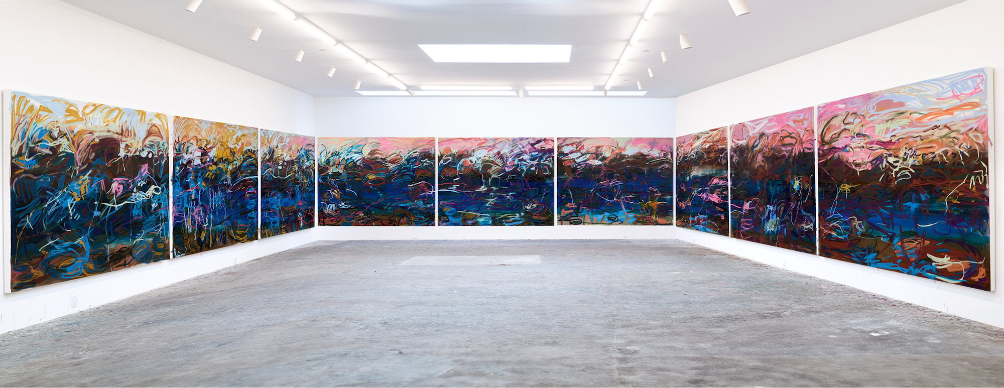 an image of nine large blue canvases with swaths of bright paint installed at Art Basel, Switzerland