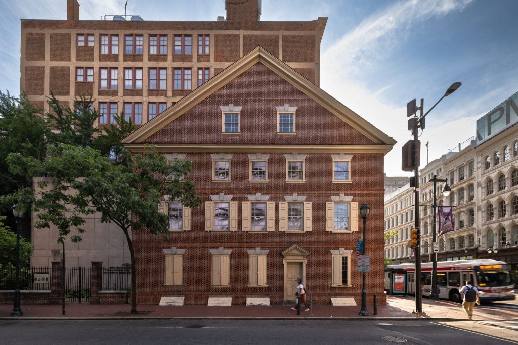 A historic house with videos of eyes displayed out the windows