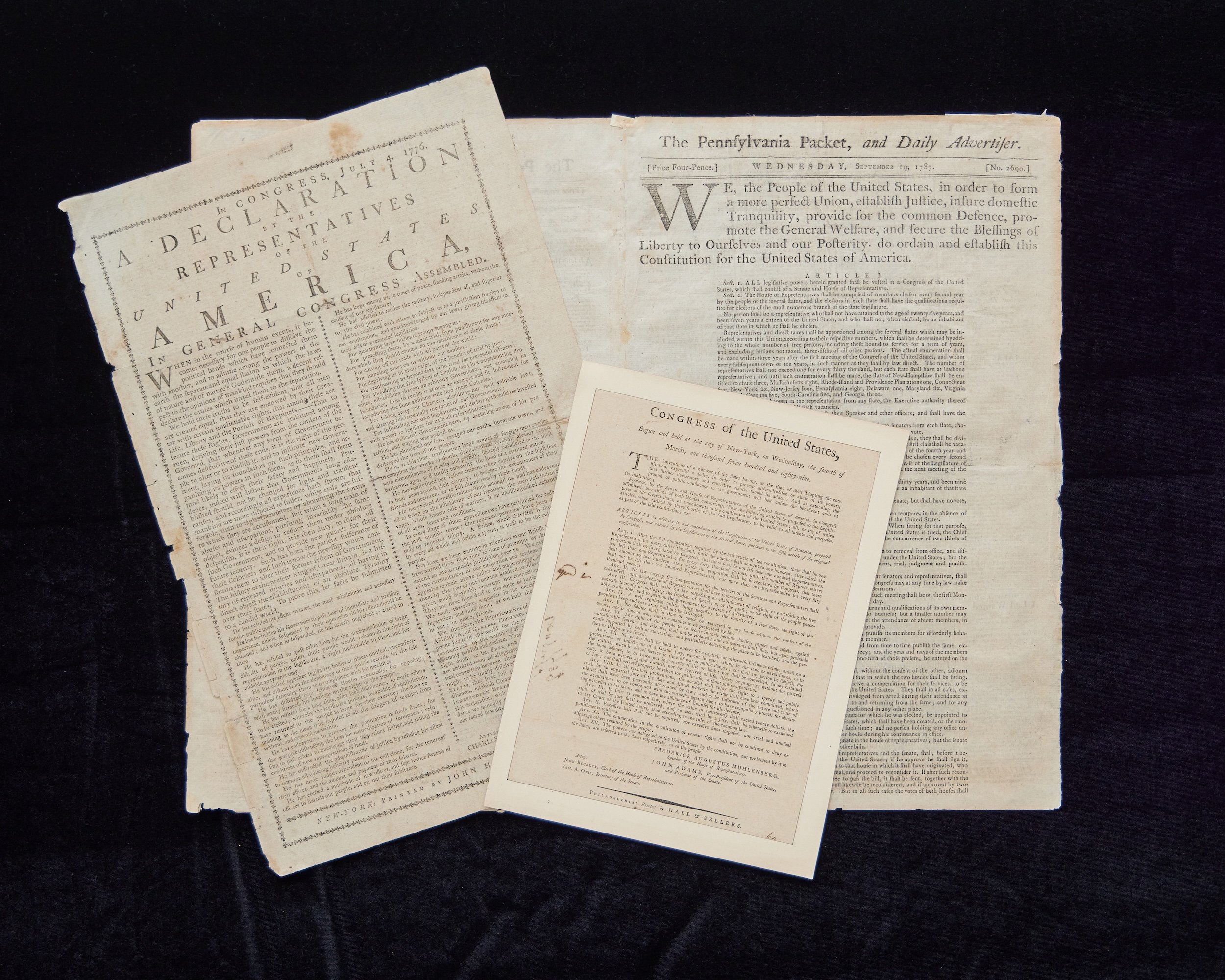 Rare original copies of America's founding documents against a dark background