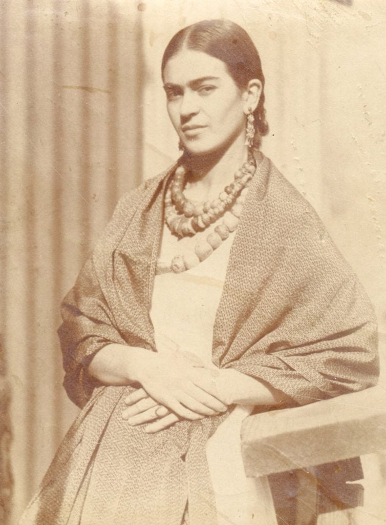 a sepia photograph of a woman in a rebozo and aztec jewelry
