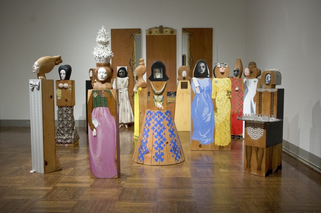 15 figures of women cut out of wooden blocks