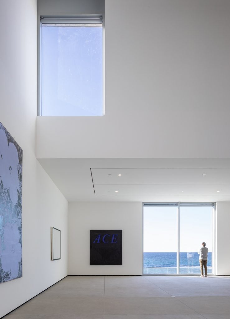 an interior view of a specious gallery in a museum with windows looking into the ocean and sky 