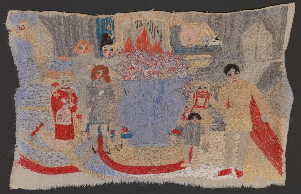 An embroidery by art brut artist Marguerite Sirvins featuring a larger than life blue vase with aster flowers in the center and an arrangement of crudely rendered figures standing around it looking out with red threads around their eyes.