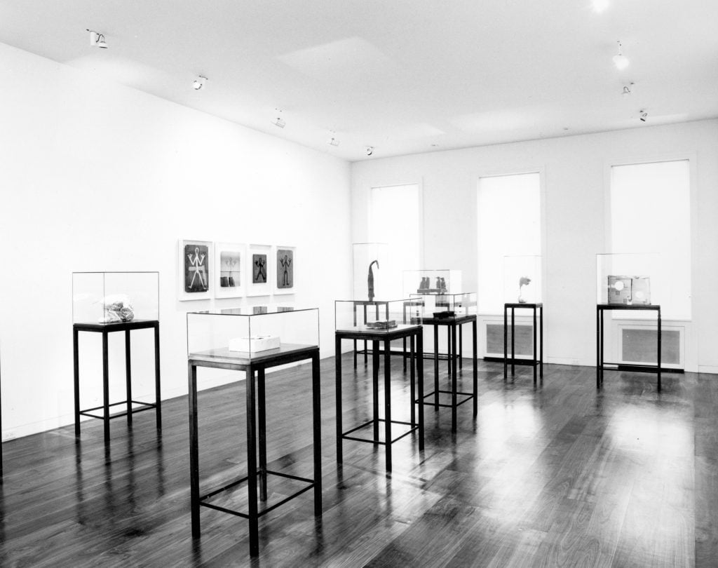 an interior view of a an art gallery with sculptures inside of plastic cubes atop stands 