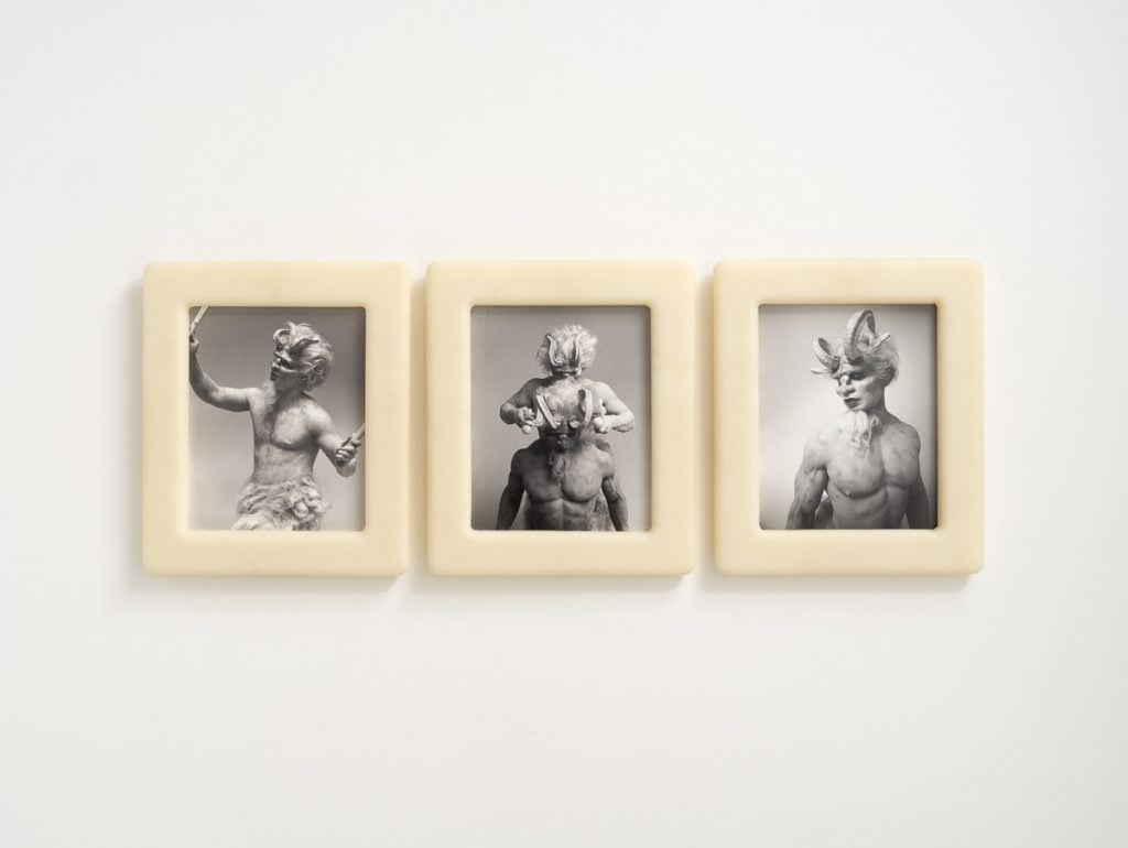three white-framed photos on a gallery wall depict a white Satyr 