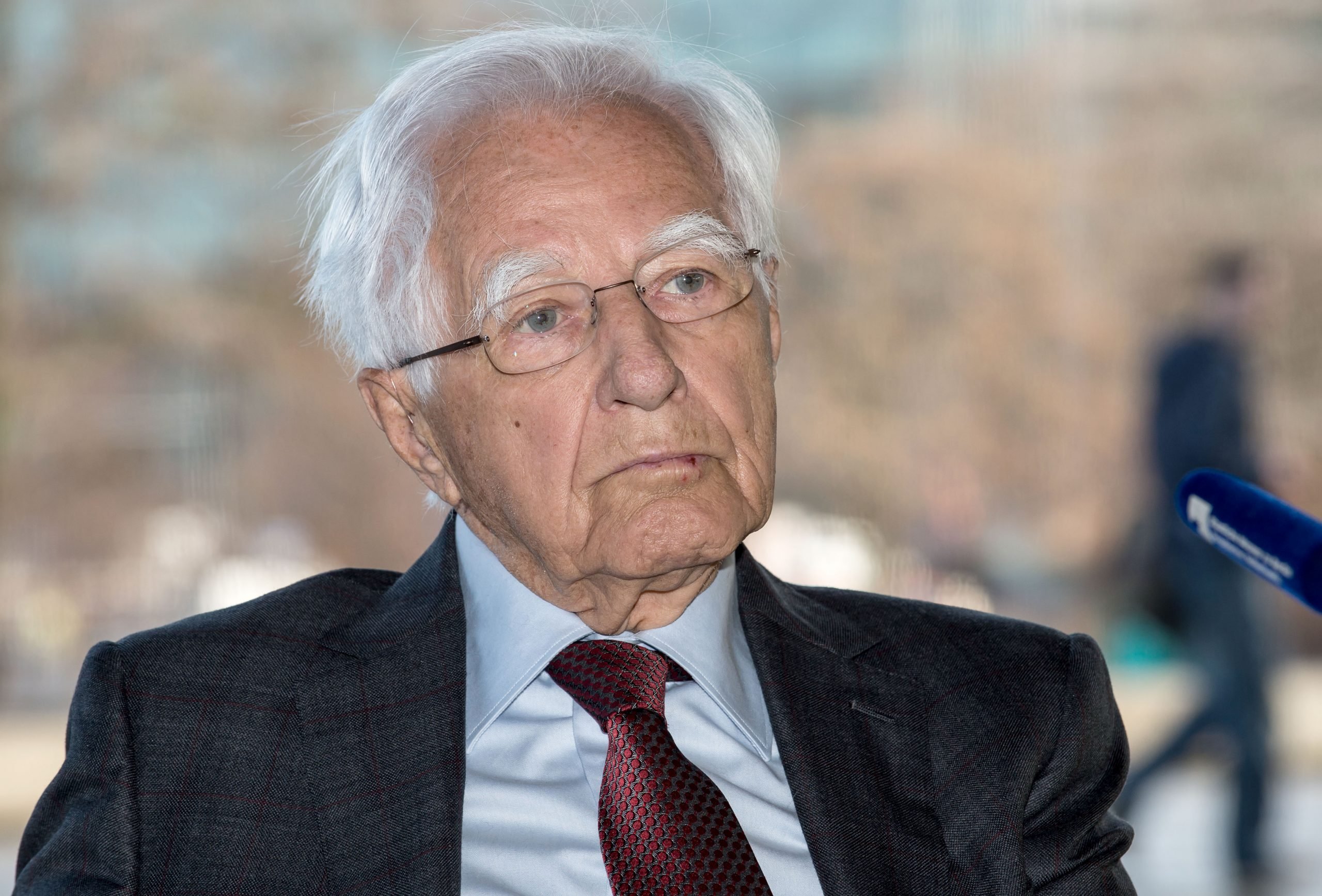 a photo of an old man wearing glasses and a suit and tie