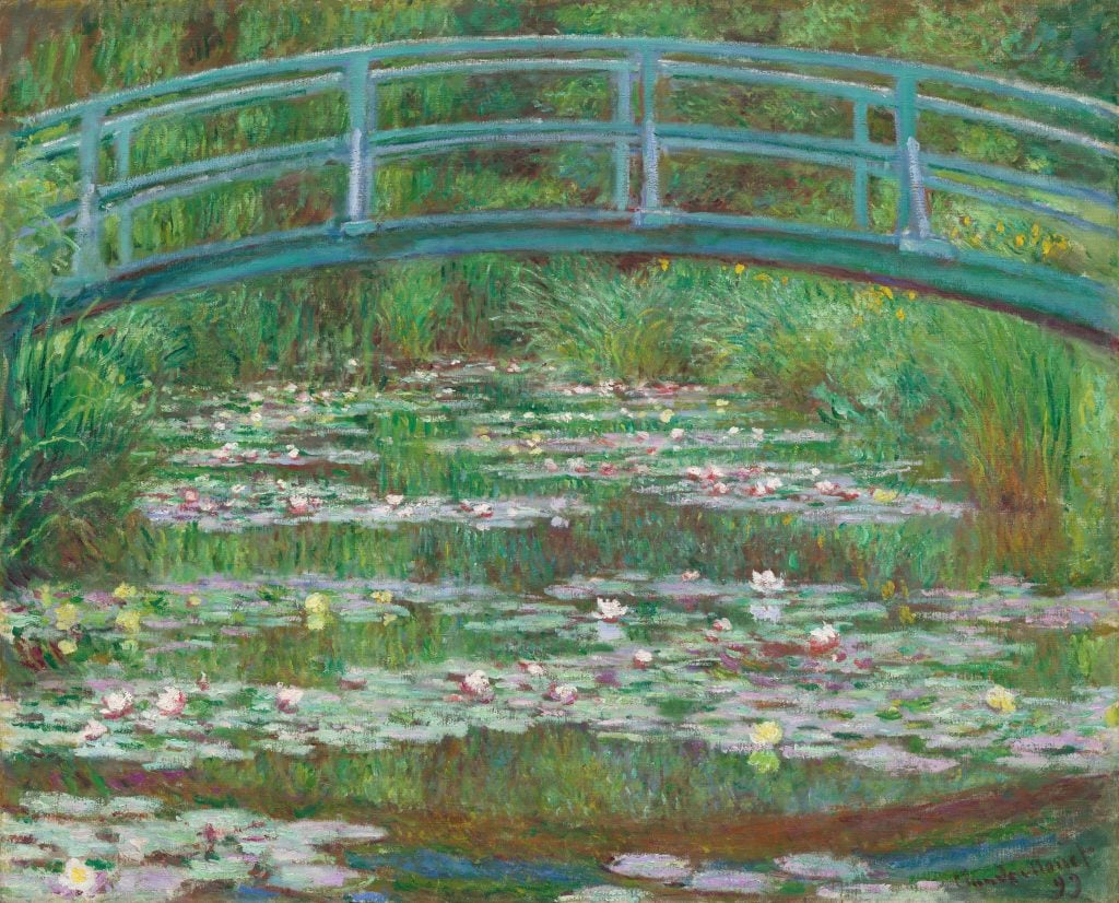 a 19th century Impressionist painting depicts a foot bridge in front of a lake filled with lily pads 