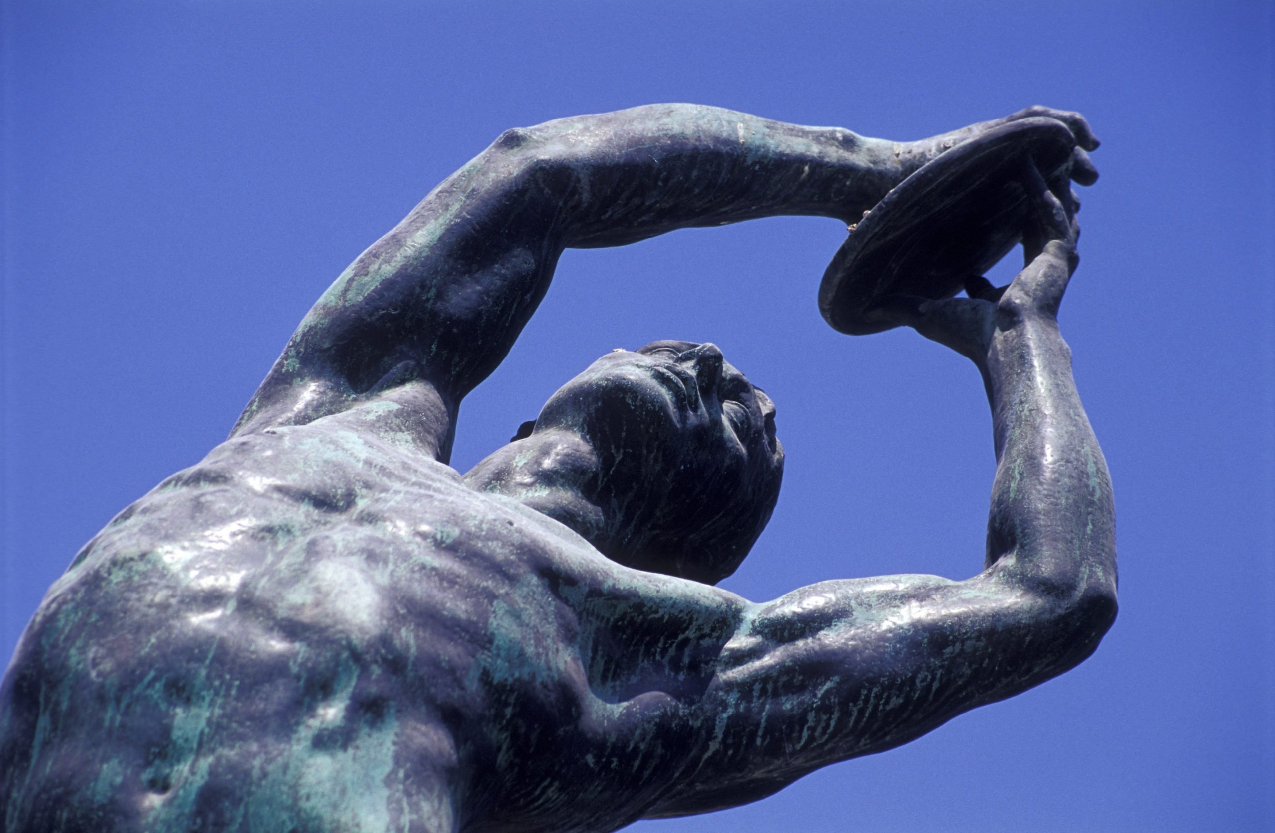 a close up of a man throwing a discus