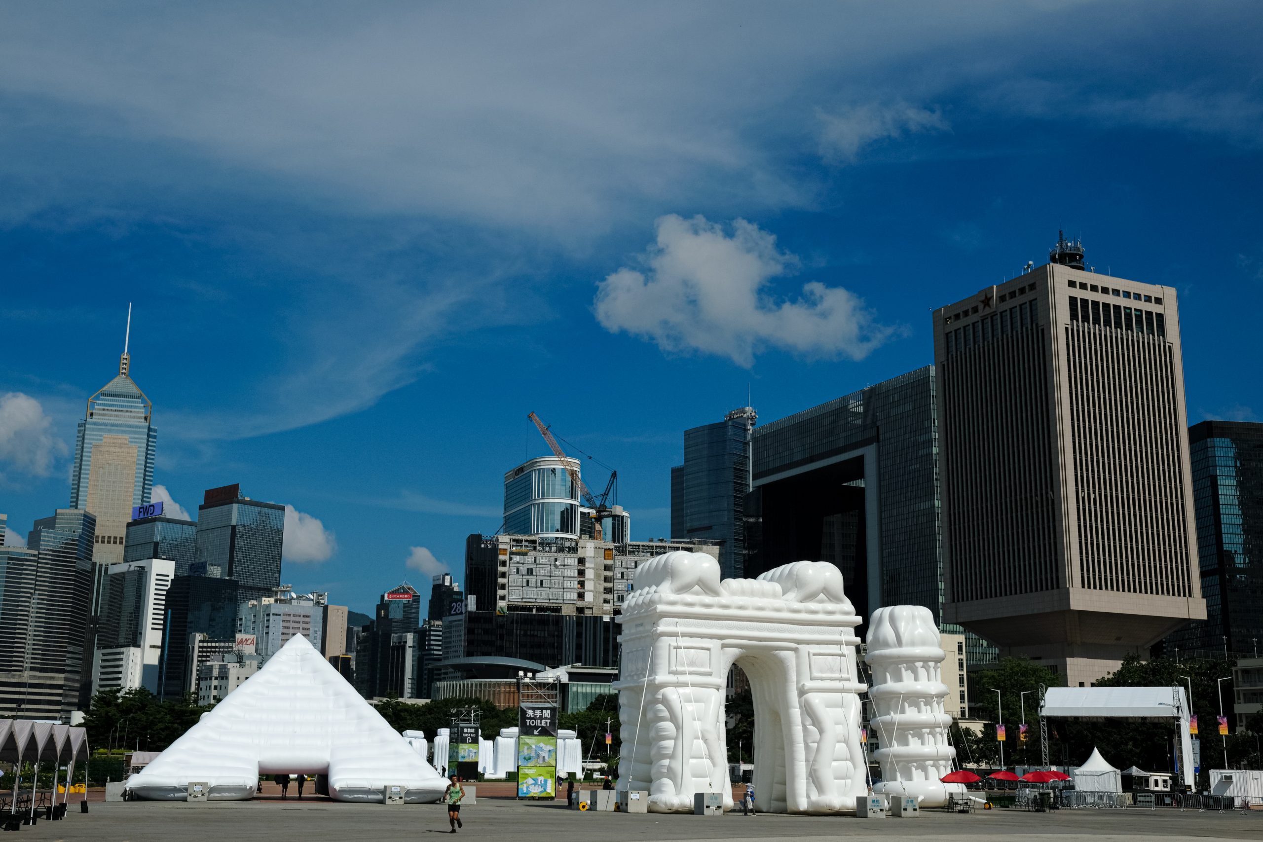 White inflatable replicas of world-famous monuments including the Pyramids of Giza and the Arc de Triomphe are seen against the Hong Kong skyline.