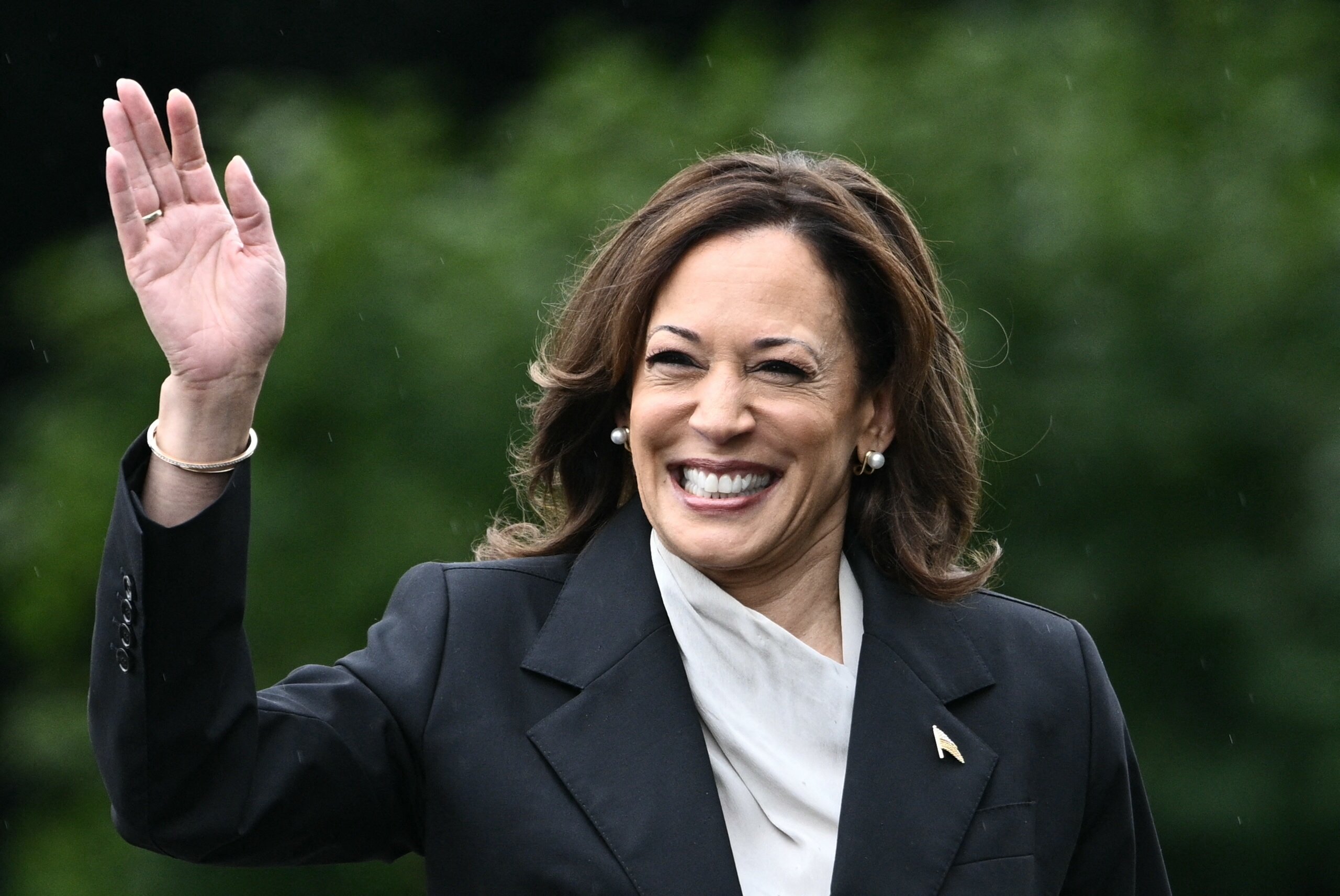 A woman in a color photo waves to the camera