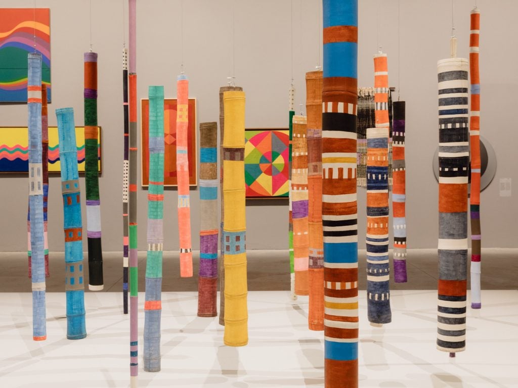 pieces of bamboo installed vertically and painted in stripes of colour