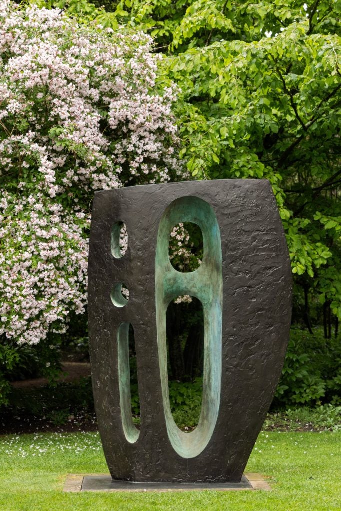 an image of a tall brown sculpture with green colored openings