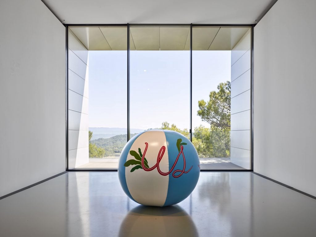 a giant beach ball sits in an art gallery