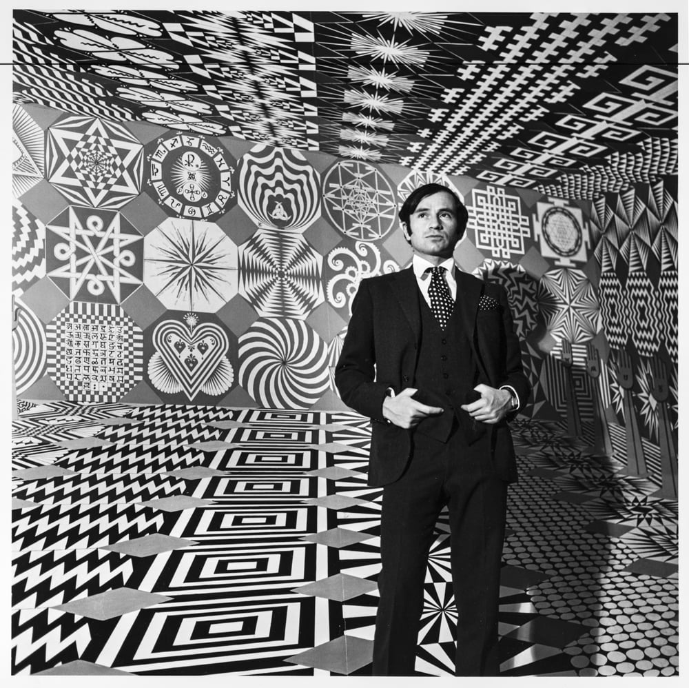 a man in a suit is standing in a psychedelic room of art