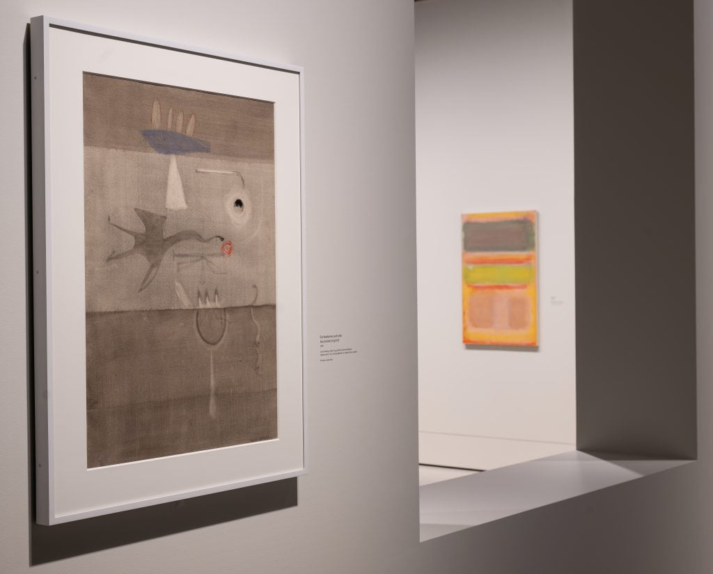 Installation view of Rothko's early surrealist painting in grey and early color field painting in yellow and green