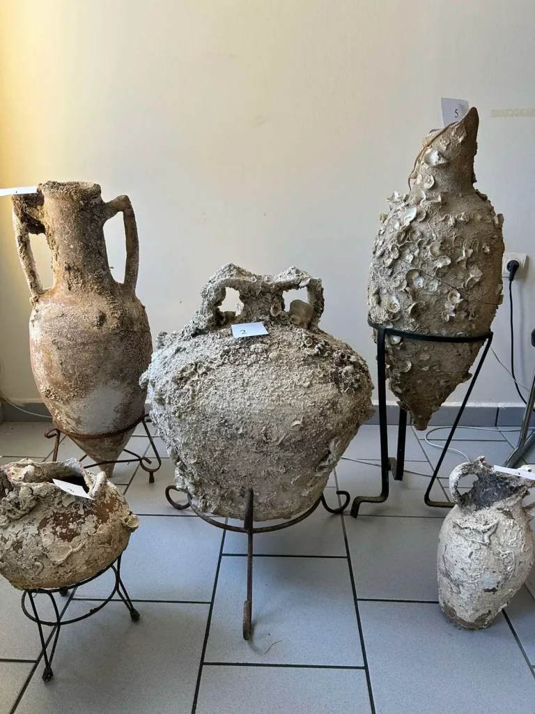 five very old ancient vases with shells stuck to the surface