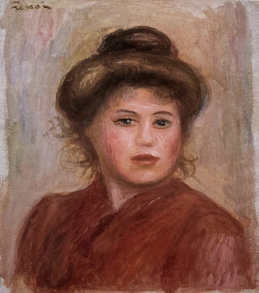 An artwork by Pierre-Auguste Renoir titled "Tête de jeune fille (Head of a Young Girl)" from 1918. This oil on canvas painting features a portrait of a young girl with a serene expression. She has brown hair styled in a bun, and her face is softly illuminated, highlighting her youthful features. The background is a blend of muted, pastel colors, typical of Renoir's impressionist style.