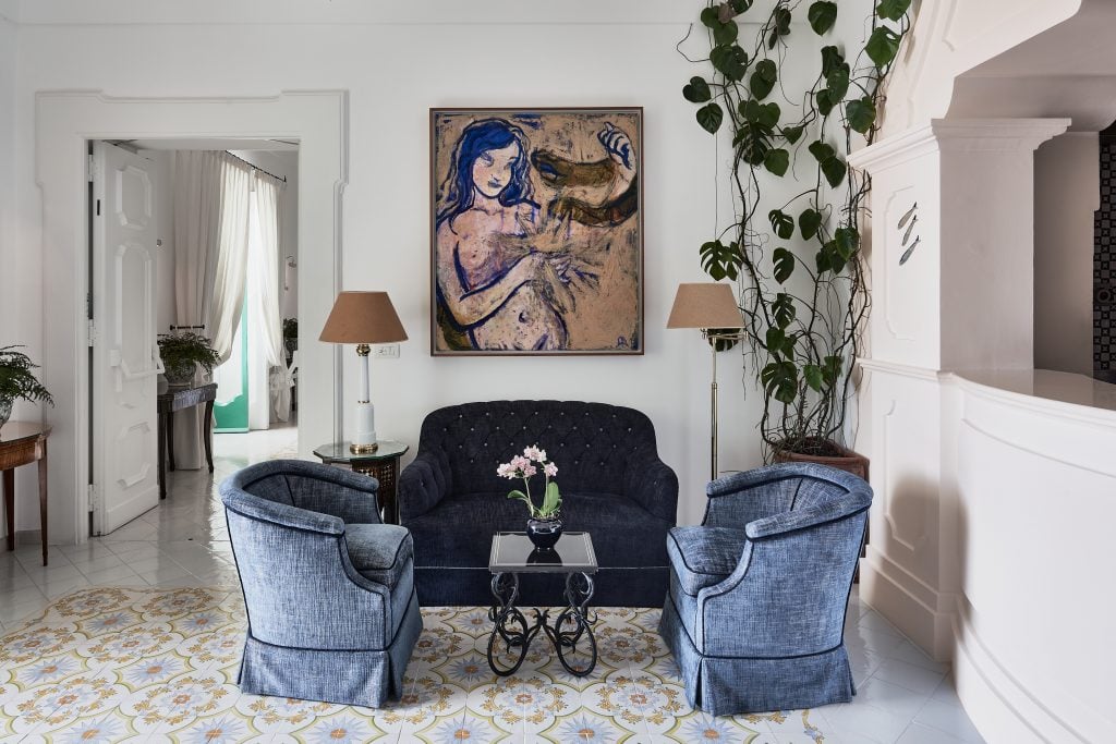 a painting of a nymphette mermaid type abstract figure hangs in a luxury hotel room 
