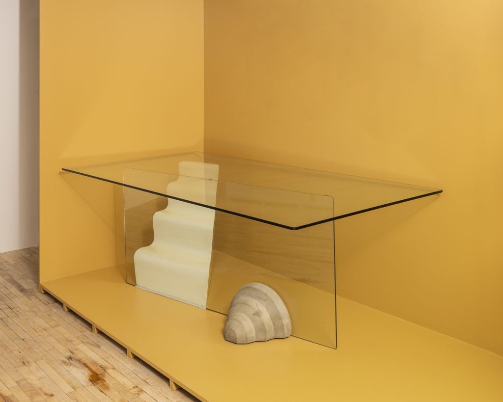 a clear glass dining table has sea elements like a sculpted shell 