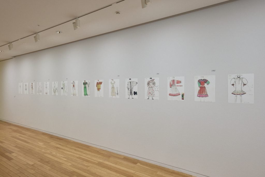 fashion sketches adorn a gallery wall