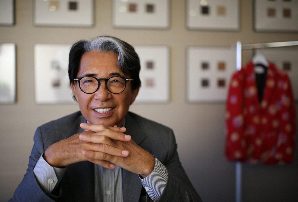 The designer Takada Kenzo is wearing a suit and an enormous smile in a portrait 