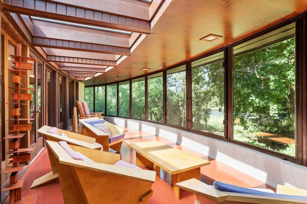 a sunny room filled with modernist seating designed by Frank Lloyd Wright