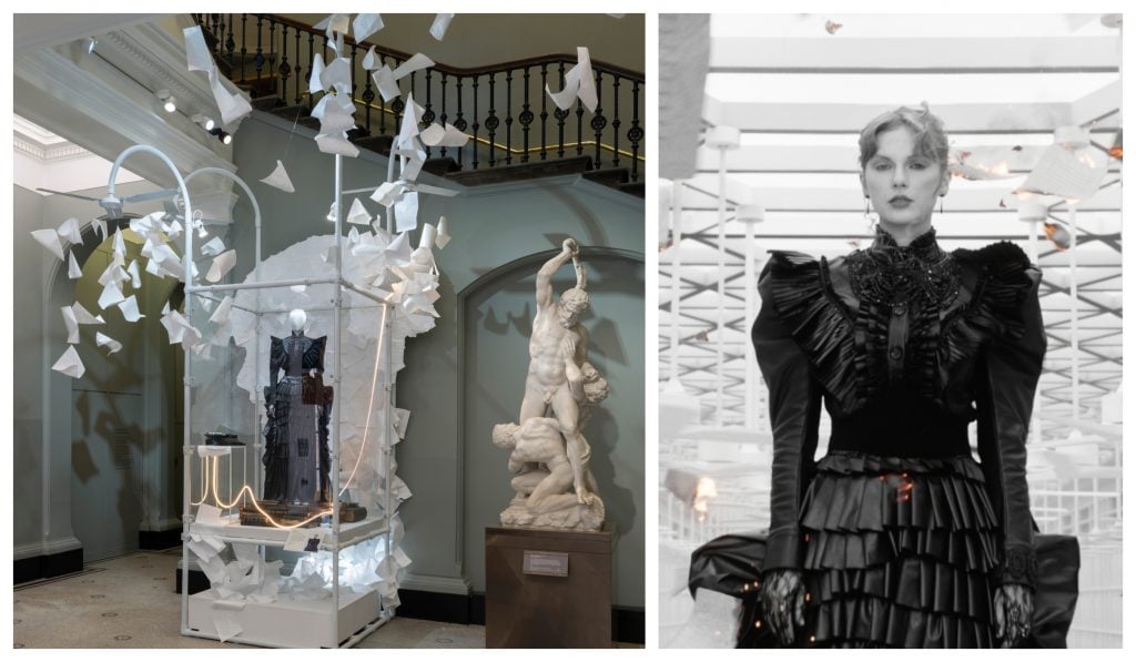 an installation with a victoriana black dress in a glass case near a stairwell and then a marble statue nearby, then a black and white photo of a woman wearing that same dress